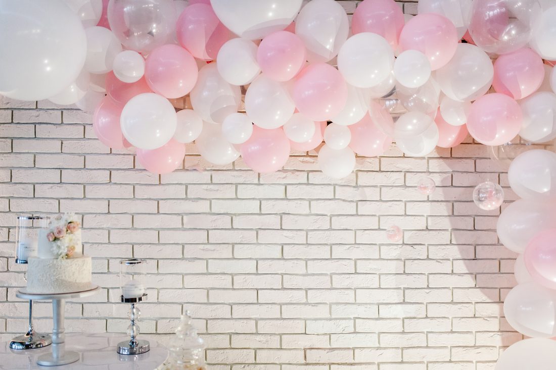 Phông tiệc bóng trắng và hồng pastel bên bánh kem